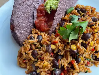Mexican rice plated with blue tacos